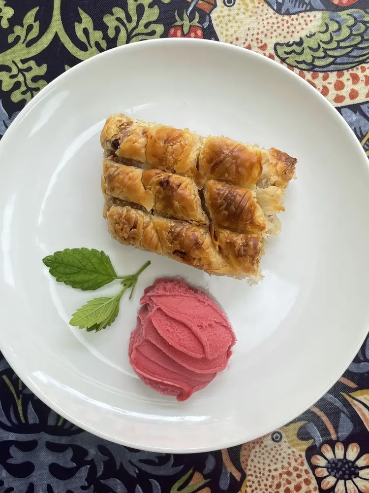 Slice of börek with raspberry sorbet and fresh mint