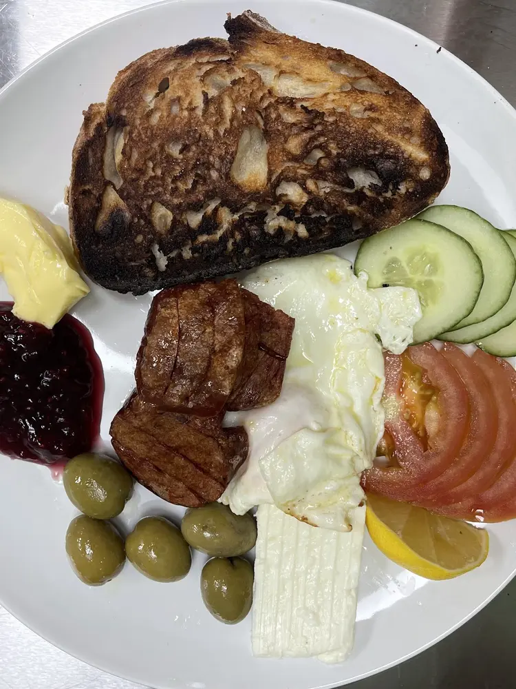 Turkish breakfast plate with sucuk, fried egg, olives, feta and sourdough toast